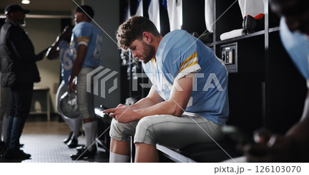Football, sports and man with phone in locker room for text message, check notifications and match break. Player, athlete and relax with smartphone for social media scroll, online news or mobile chat 126103070