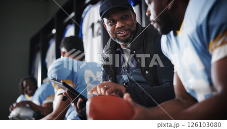 Black men, coach and football captain on tablet in locker room for game plan, strategy and layout. African mentor, athlete and sports trainer on technology for brainstorming match and play routine 126103080