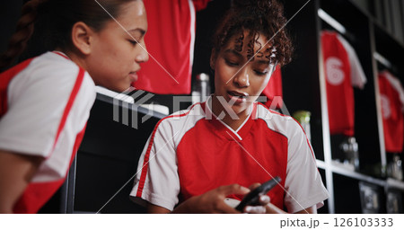 Online, team and girls with smartphone, gym and conversation for match on website, watching and sports. Locker room, friends and people with mobile for streaming, talking and preparing for game Online, team and girls with smartphone, gym and conversation for match on website, watching and sports. Locker room, friends and people with mobile for streaming, talking and preparing for game 126103333