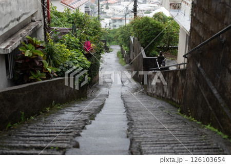 正面に街の見える雨で路面が濡れた坂道 126103654