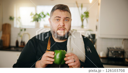 Cooking, portrait and man in kitchen, green pepper and influencer with ingredients, tutorial and live streaming. Face, person or chef with recipe, home or filming with video broadcasting or explain 126103708