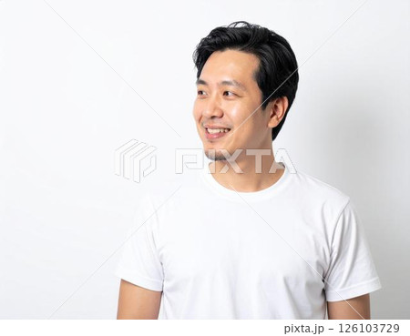 横向きで笑顔を見せる日本人男性（白Tシャツ・白背景） 126103729