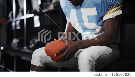 Hands, football and player with ball in locker room for preparation, sports match and waiting on game. Male athlete, getting ready and half time of competition, fitness challenge and tournament event Hands, football and player with ball in locker room for preparation, sports match and waiting on game. Male athlete, getting ready and half time of competition, fitness challenge and tournament event 126103826