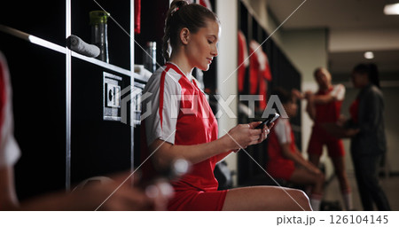 Cellphone, woman and athlete in locker room for game, match or practice with scrolling on social media. Tech, relax and female soccer player with phone for networking on mobile app in changing area. Cellphone, woman and athlete in locker room for game, match or practice with scrolling on social media. Tech, relax and female soccer player with phone for networking on mobile app in changing area. 126104145