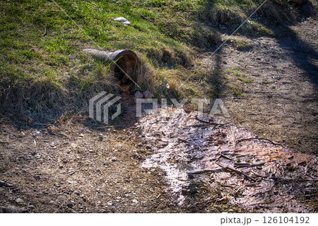 Polluted Water Flowing From a Rusty Drain Pipe Into Contaminated Soil in a Rural Outdoor Environment Polluted Water Flowing From a Rusty Drain Pipe Into Contaminated Soil in a Rural Outdoor Environment 126104192