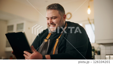 Tablet, man and chef in kitchen for online recipe planning, instructions or research for cook book. Happy, digital technology and male person reading culinary review on restaurant business in home. Tablet, man and chef in kitchen for online recipe planning, instructions or research for cook book. Happy, digital technology and male person reading culinary review on restaurant business in home. 126104201