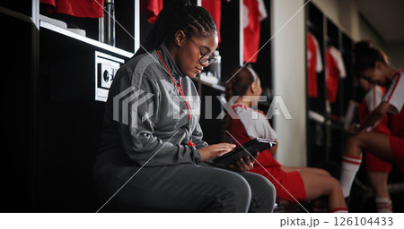 Woman, soccer coach and schedule with tablet for game time, matchup or attendance list in locker room. Female person, manager or coordinator with technology or app for fixtures or player registration 126104433