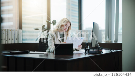 Tablet, documents and reading with business woman in office for client invoice, account payroll and savings report. Feedback, finance statements and capital profit with person in agency for planning 126104434