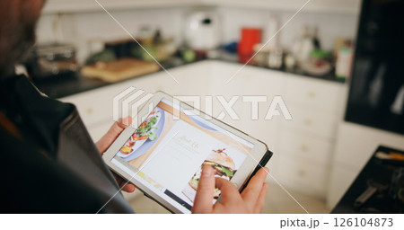 Person, chef and hands with tablet screen for about us, recipe or online menu in kitchen at home. Closeup, culinary artist or restaurant website with technology display for ingredients at house Person, chef and hands with tablet screen for about us, recipe or online menu in kitchen at home. Closeup, culinary artist or restaurant website with technology display for ingredients at house 126104873