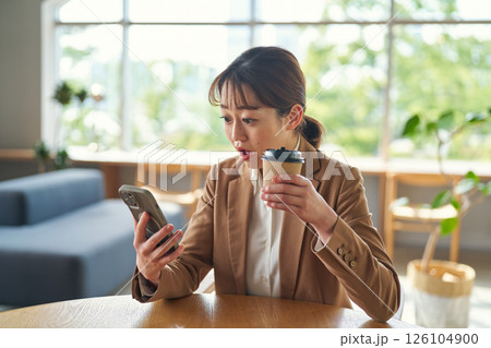 スマートフォンを見て驚く女性 126104900