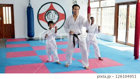 Sensei, lesson and man with children in karate class, self defense training or martial arts for youth for combat education. Taekwondo, smile and male instructor with student kids for coaching in dojo 126104951