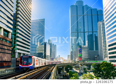 BTS Skytrain travels through central Bangkok surrounded by modern skyscrapers on a clear sunny morning 126106175