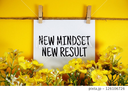 New Mindset New Result text on paper card with flower blooming decoration on yellow background 126106726
