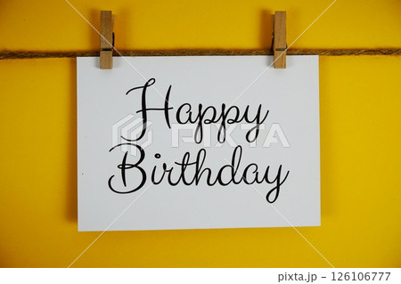 Happy Birthday text on paper card on yellow background 126106777