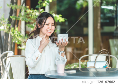 カフェで化粧直し・メイク直しをする女性・ビジネスウーマン(口紅・リップ・ルージュ・グロス・唇・唇) 126107662