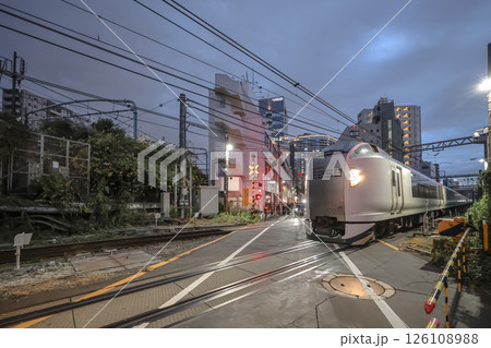 City Train Passing Through Urban Railway Crossing at Twilight Dec 7 2024 126108988