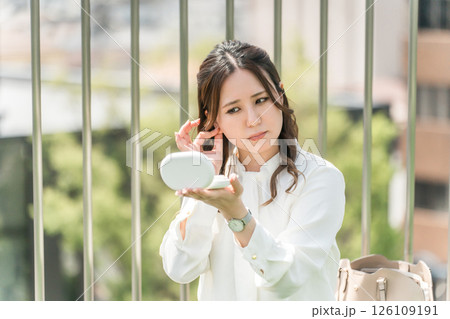 鏡を見ながら耳を触る女性,ビジネスウーマン 鏡を見ながら耳を触る女性,ビジネスウーマン 126109191
