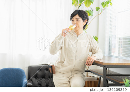 部屋でシャンパンを飲む女性 126109239