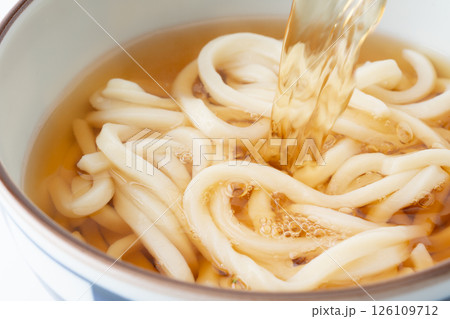 美味しそうなうどんに注ぐ汁のクローズアップ 126109712