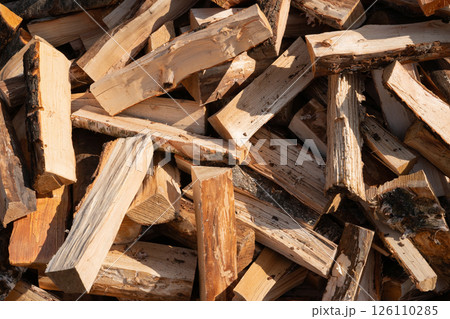 Stack of cut firewood logs in sunlight displaying natural texture Stack of cut firewood logs in sunlight displaying natural texture 126110285