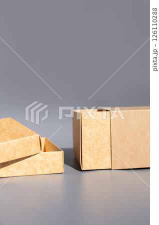 Brown cardboard gift boxes on gray background with open lid and sliding drawer Brown cardboard gift boxes on gray background with open lid and sliding drawer 126110288