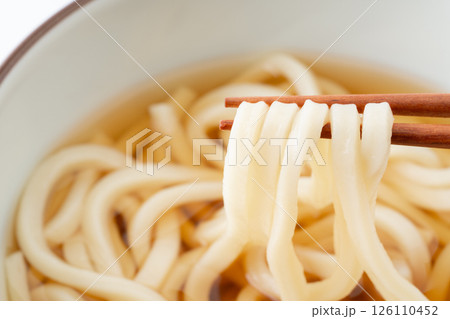 お箸で持ち上げたうどんの麺のクローズアップ 126110452