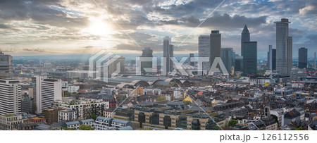 Aerial view of Frankfurt, Germany, featuring modern skyscrapers like Commerzbank Tower, Westend Tower, and the central train station under a dramatic sky. Aerial view of Frankfurt, Germany, featuring modern skyscrapers like Commerzbank Tower, Westend Tower, and the central train station under a dramatic sky. 126112556