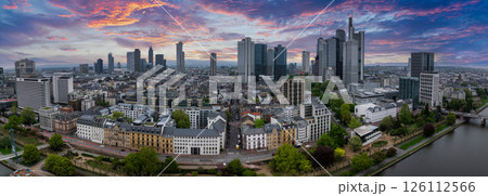 Aerial view of Frankfurt, Germany, featuring the skyline with Commerzbank Tower, Main Tower, tree lined streets, and the Main River at sunset. 126112566