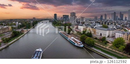 Aerial view of Frankfurt, Germany, showcasing the River Main, modern skyscrapers like Main Tower, historic buildings, and vibrant sunset hues. Aerial view of Frankfurt, Germany, showcasing the River Main, modern skyscrapers like Main Tower, historic buildings, and vibrant sunset hues. 126112592