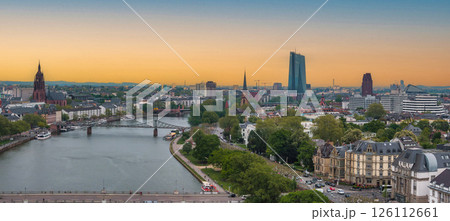 Aerial view of Frankfurt, Germany, at sunset featuring the Main River, Eiserner Steg bridge, Frankfurt Cathedral, ECB tower, and lush greenery. Aerial view of Frankfurt, Germany, at sunset featuring the Main River, Eiserner Steg bridge, Frankfurt Cathedral, ECB tower, and lush greenery. 126112661