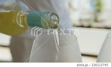 Waiter Pouring White Wine Inside The Guest Glass For Lunch Waiter Pouring White Wine Inside The Guest Glass For Lunch 126112745