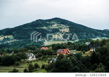 Scenic view of a hillside village with scattered houses among forested and agricultural slopes. Eco-tourism, sustainable tourism, cultural preservation, authentic village experiences... 126113828
