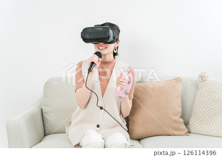 VRゴーグルをつけて家でカラオケ・メタバースを楽しむアジア人女性 126114396