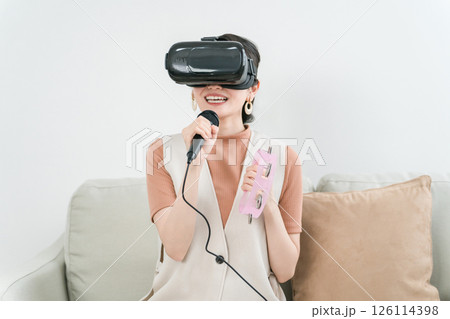 VRゴーグルをつけて家でカラオケ・メタバースを楽しむアジア人女性 126114398