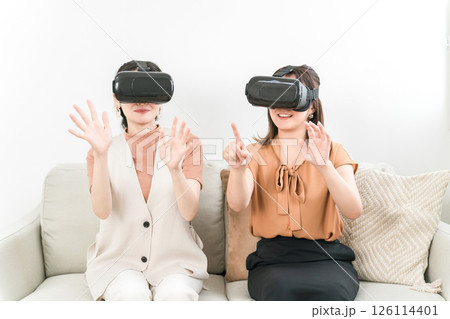 家でVRゴーグルをつけて仮想空間を楽しむ女性たち 家でVRゴーグルをつけて仮想空間を楽しむ女性たち 126114401