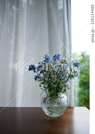 テーブルの上の花瓶に入った青と白の花束 126114488
