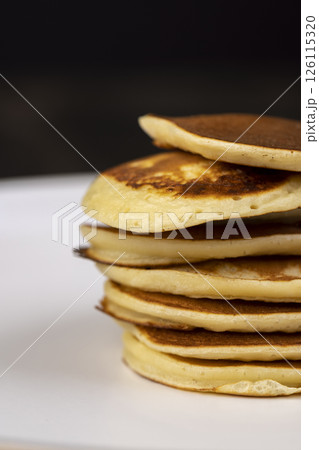 pancakes stacked together on a bowl, a tower of small milk pancakes on a bowl pancakes stacked together on a bowl, a tower of small milk pancakes on a bowl 126115320