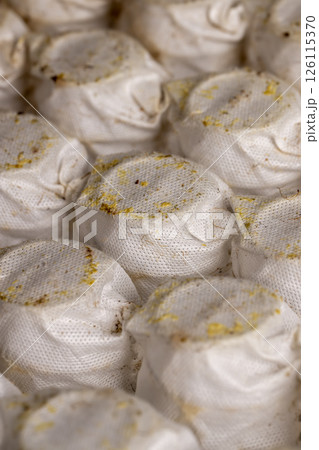 glued together old mattress springs in white fabric after long-term use, close up 126115370