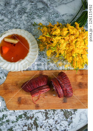 Spring tea party with yellow flowers, bow-shaped dessert and black tea on grey background Spring tea party with yellow flowers, bow-shaped dessert and black tea on grey background 126115492