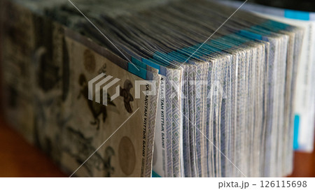 Thick wad of money cash on table 126115698