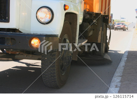 Street cleaning machine drives on the city sЫtreet. Сleaning the road with pressurized water. Using water. Watering. Cleaning concept. Front view. Powerful water jet Street cleaning machine drives on the city sЫtreet. Сleaning the road with pressurized water. Using water. Watering. Cleaning concept. Front view. Powerful water jet 126115714