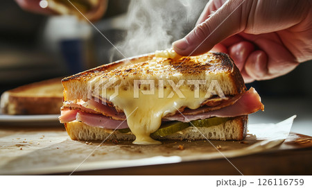 Hot Cuban sandwich being pulled apart with melted cheese strings and steam, showing layers of ham, pickles, and mustard in a warm bistro setting with golden light Hot Cuban sandwich being pulled apart with melted cheese strings and steam, showing layers of ham, pickles, and mustard in a warm bistro setting with golden light 126116759