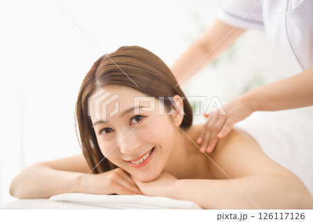 エステサロンでマッサージを受ける若い女性 126117126
