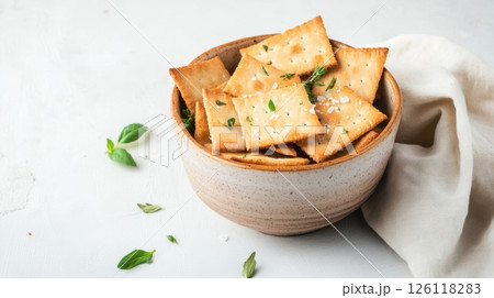 Rustic sourdough crackers with herbs and sea salt in ceramic bowl, soft light and linen napkin, perfect for sustainable snack and healthy eating visuals. 126118283