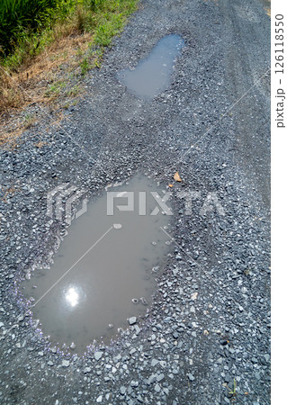 雨上がりの砂利道にできた水たまり 雨上がりの砂利道にできた水たまり 126118550