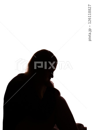 Silhouette of young woman sitting with loose hair, depressed 126118827