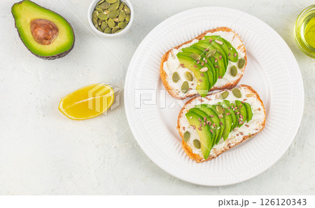 Healthy avocado toasts with sliced avocado, cheese for breakfast or lunch. Vegetarian food. Vegan menu. top view. copy space 126120343