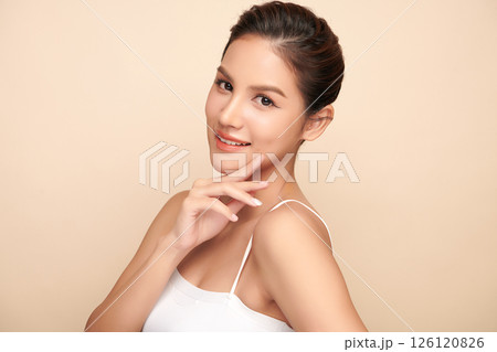 A beautiful young Asian woman with clean, fresh skin against a beige background. Skincare, facial treatment, cosmetology, beauty, and spa. An elegant portrait of an Asian woman. A beautiful young Asian woman with clean, fresh skin against a beige background. Skincare, facial treatment, cosmetology, beauty, and spa. An elegant portrait of an Asian woman. 126120826