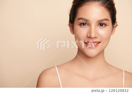 A beautiful young Asian woman with clean, fresh skin against a beige background. Skincare, facial treatment, cosmetology, beauty, and spa. An elegant portrait of an Asian woman. A beautiful young Asian woman with clean, fresh skin against a beige background. Skincare, facial treatment, cosmetology, beauty, and spa. An elegant portrait of an Asian woman. 126120832
