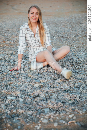 Beautiful woman smiling in summer dress on the beach by the sea Beautiful woman smiling in summer dress on the beach by the sea 126121804